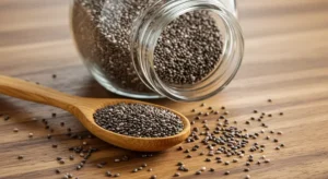 colher de madeira com chia ao lado de um pote de vidro com chia